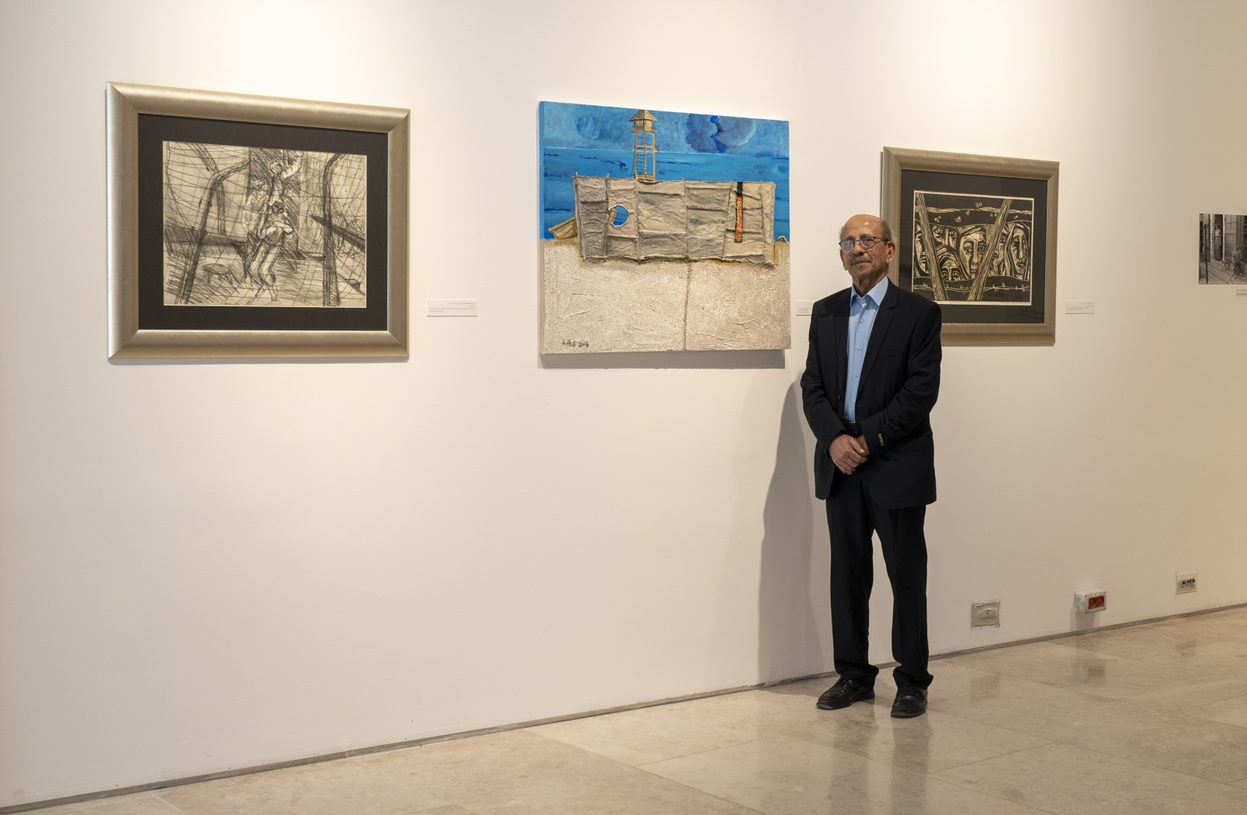 Abed Abdi standing in front of his artworks at the Palestinian Museum, Ramallah, 2020